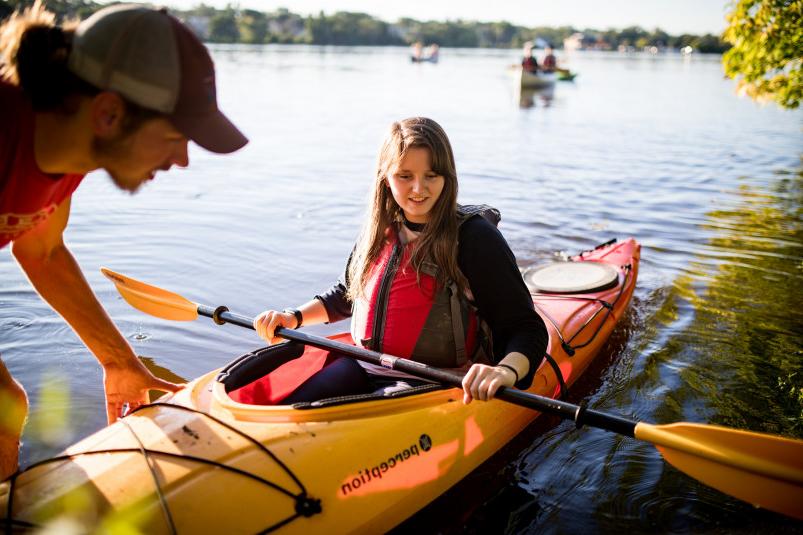 A member of the Buccaneer Boathouse group assists other students in experiencing paddle sports on...