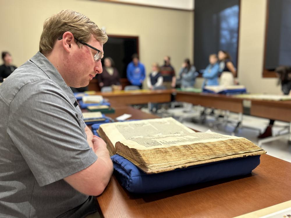 Jared Saathoff'24 inspects a rare book at the Newberry Library in Chicago.