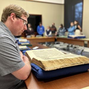 Jared Saathoff’24 inspects a rare book at the Newberry Library in Chicago.