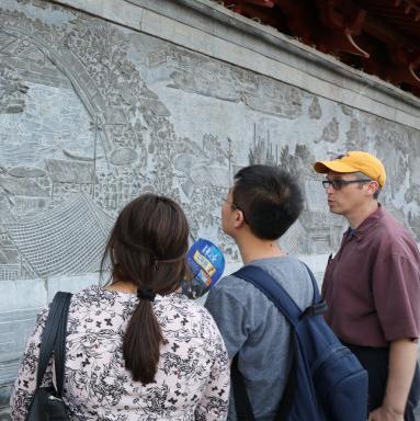在景观期间，教授和学生研究中国黄河地区的一个浮雕板...