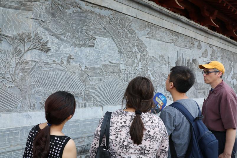 Professors and students study a relief panel in the Yellow river area of China during the Landsca...